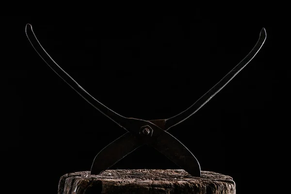 Close up view of retro rusty scissors on wooden stump isolated on black — Stock Photo