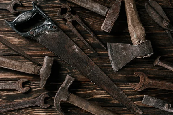 Disposición plana con surtido de herramientas oxidadas vintage en la superficie de madera - foto de stock