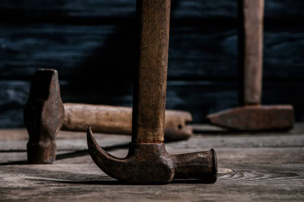 Close up view of retro rusty hammers on wooden planks surface — Stock Photo