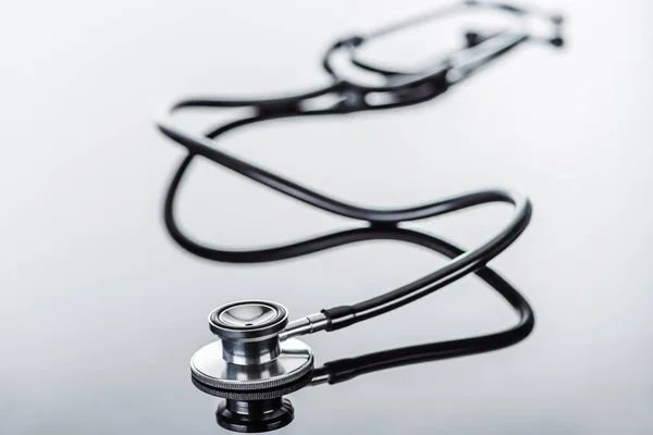 Selective focus of stethoscope on glass surface — Stock Photo