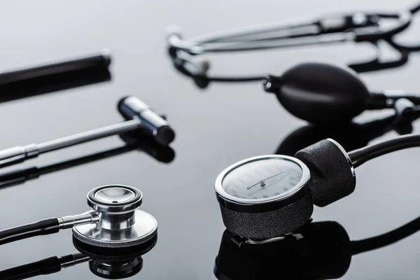 Selective focus of tonometer, reflex hammer and stethoscope on glass surface — Stock Photo