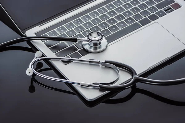 Close up view of stethoscope and laptop on glass surface — Stock Photo