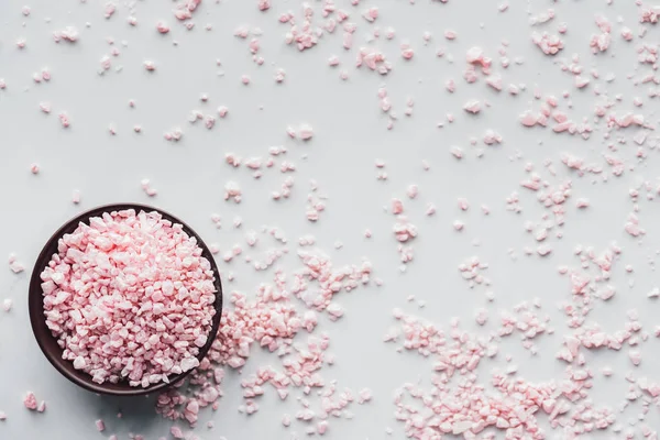 Вид зверху на рожеву морську сіль в мисці на білому тлі — стокове фото