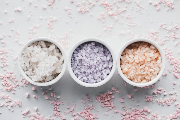 Vue de dessus de sel de mer coloré dans des bols sur blanc — Photo de stock