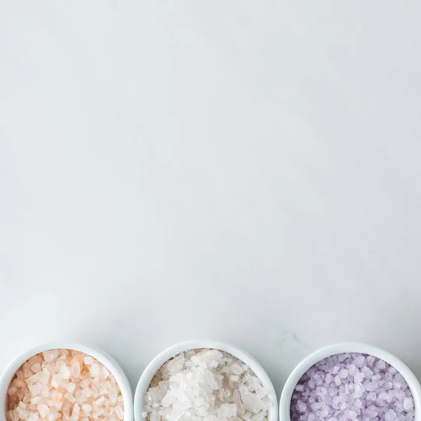 Верхний вид красочной морской соли в мисках на белом фоне — стоковое фото
