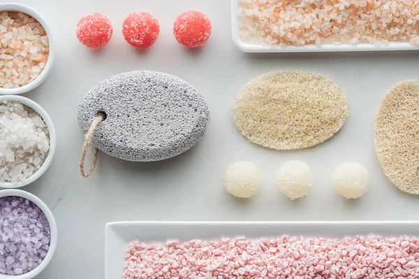 Vue de dessus de divers sel de mer, éponges et savon fait à la main sur blanc — Photo de stock