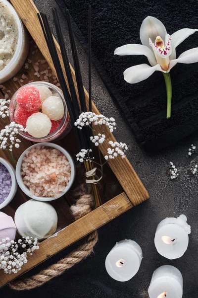 Top view of beautiful orchid, towel, burning candles and spa accessories on grey — Stock Photo