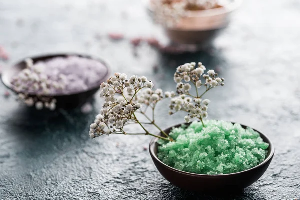 Close-up view of sea salt in bowls and small white flowers, selective focus — Stock Photo