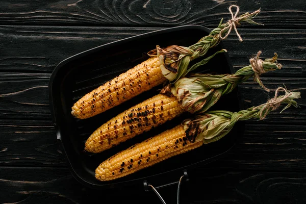 Вид зверху смачна смажена кукурудза на сковороді на дерев'яному столі — стокове фото