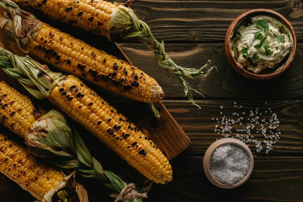 Vue du dessus de maïs grillé, sel et beurre avec persil sur table en bois — Photo de stock