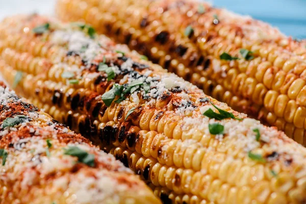 Selective focus of delicious grilled corn with salt, parsley and chili spice — Stock Photo