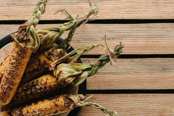 Top view of grilled salted corn on plate on wooden table — Stock Photo