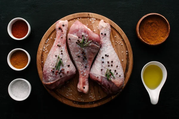 Vista dall'alto delle cosce di tacchino sul tagliere con olio, paprica e sale — Foto stock