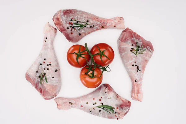 Vue du dessus des cuisses de poulet et des tomates cerises, isolées sur blanc — Photo de stock