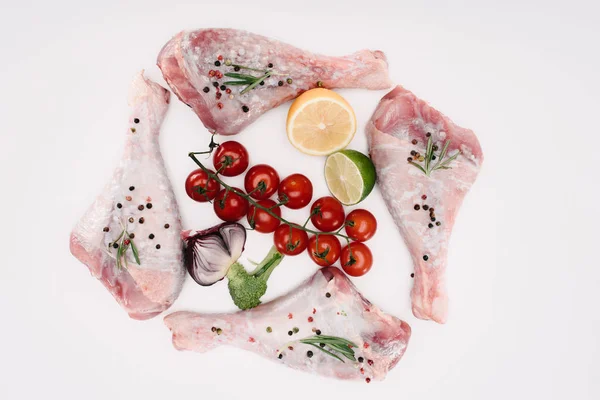 Top view of turkey legs with cherry tomatoes, lime and lemon, isolated on white — Stock Photo