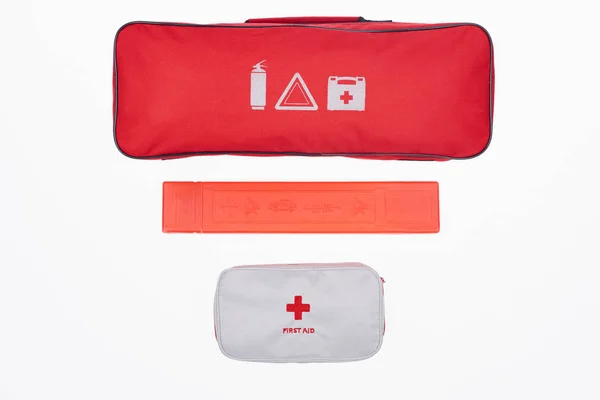 Vue du dessus du sac à main automobile rouge et de la trousse de premiers soins isolés sur blanc — Photo de stock
