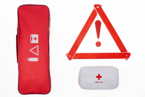 Posa piatta con borsa automobilistica, kit di pronto soccorso e triangolo di avvertimento isolato su bianco — Foto stock