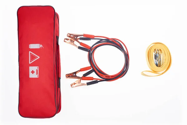 Flat lay with arrangement of automotive handbag, car tow rope and jump start cables isolated on white — Stock Photo