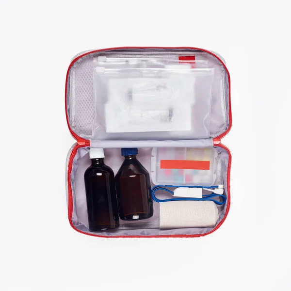 Vista superior do kit de primeiros socorros automotivos com diferentes medicamentos isolados em branco — Fotografia de Stock