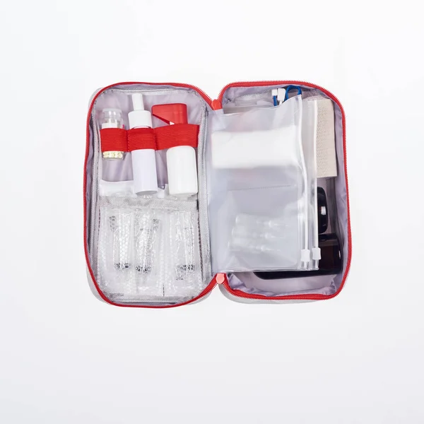 Vista superior del botiquín automotriz de primeros auxilios con diferentes medicamentos aislados en blanco - foto de stock