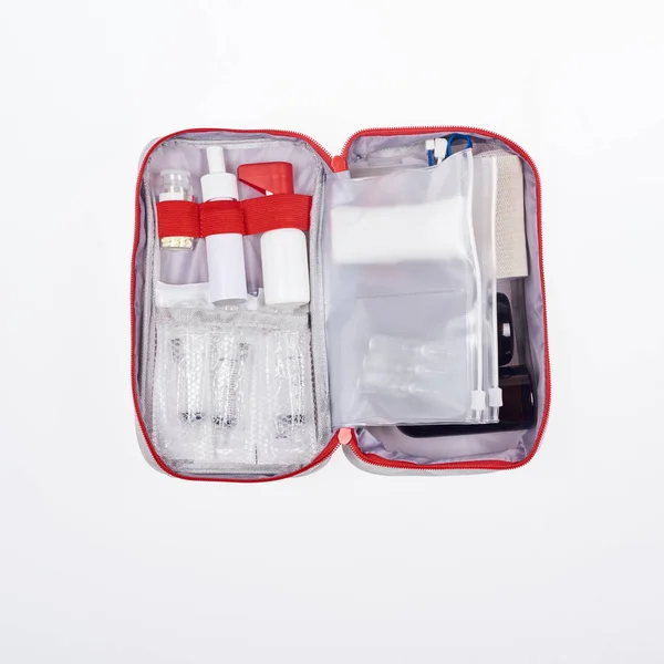 Vue du dessus de la trousse de premiers soins automobile avec différents médicaments isolés sur blanc — Photo de stock