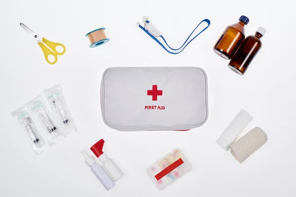 Flat lay com kit de primeiros socorros automotivos com vários medicamentos isolados em branco — Fotografia de Stock