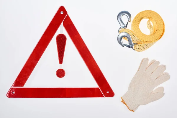 Flat lay with warning triangle, gloves and car tow rope isolated on white — Stock Photo