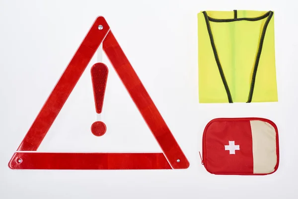 Plano con triángulo de advertencia, botiquín de primeros auxilios y chaleco reflectante aislado en blanco - foto de stock