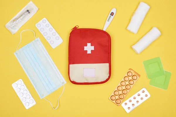 Top view of first aid kit with various medicines isolated on yellow — Stock Photo