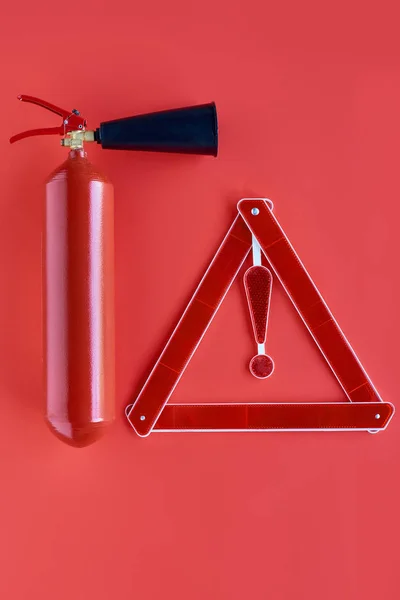 Vista superior do extintor de incêndio e triângulo de aviso isolado no vermelho — Fotografia de Stock
