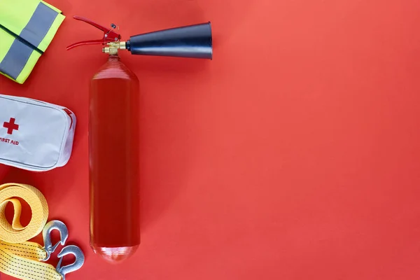 Vista dall'alto dell'estintore e degli accessori automobilistici su sfondo rosso — Foto stock