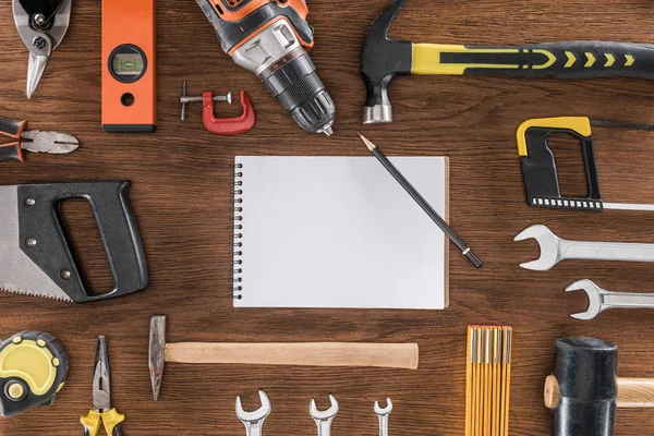 Draufsicht auf leeres Lehrbuch umgeben von verschiedenen Werkzeugen auf Holztisch — Stockfoto