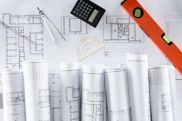 Top view of architect blueprints, ruler, protractor, calculator, divider and spirit level — Stock Photo