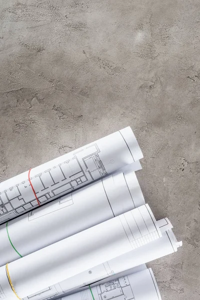 Vue de dessus des plans architecturaux disposés sur la surface du béton — Photo de stock