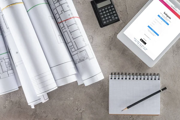 Top view of architect workplace with empty textbook, calculator and digital tablet with instagram on screen — Stock Photo