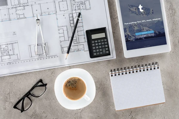 Vue de dessus du lieu de travail de l'architecte avec plan, diviseur, café et tablette numérique avec tumblr à l'écran — Photo de stock