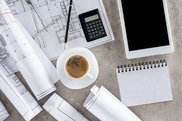 Top view of architect workplace with coffee cup, blueprints, calculator and digital tablet with blank screen — Stock Photo