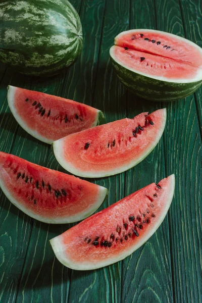 Nahaufnahme von Wassermelonenscheiben auf grüner Holzoberfläche — Stockfoto