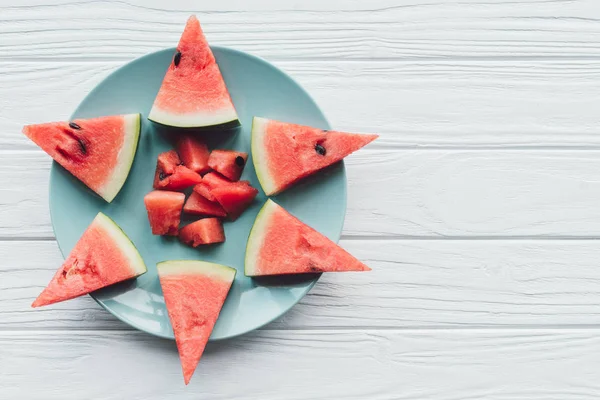 Top view of fresh watermelon pieces on plate on white wooden surface — Stock Photo