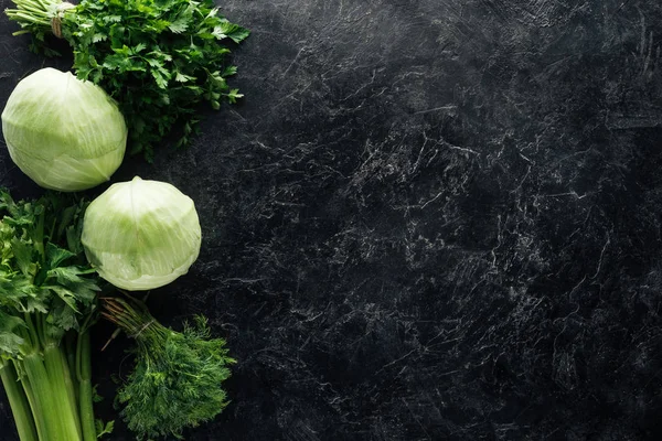 Vista superior de la composición de los alimentos con verduras frescas verdes en la mesa de mármol negro - foto de stock