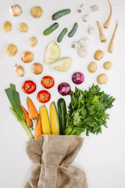 Top view of fresh raw vegetables and sackcloth arranged isolated on whit — Stock Photo