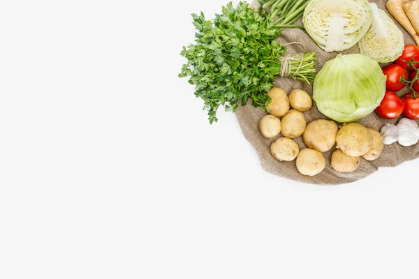 Vista superior de verduras maduras de temporada dispuestas en saco aislado en blanco - foto de stock