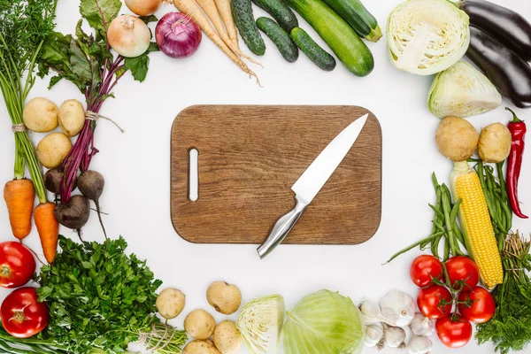 Tendido plano con verduras maduras de otoño y tabla de cortar de madera con cuchillo aislado en blanco - foto de stock