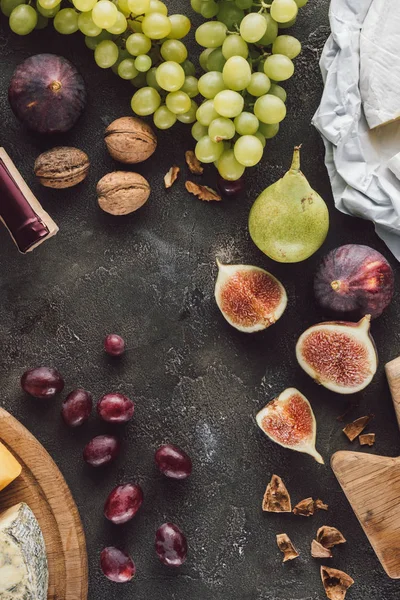 Плоский слой с фруктами, сыром и орехами сена на темной поверхности — стоковое фото