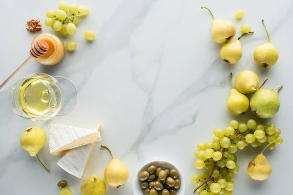 Flat lay with camembert cheese, wine and fruits on white marble surface — Stock Photo