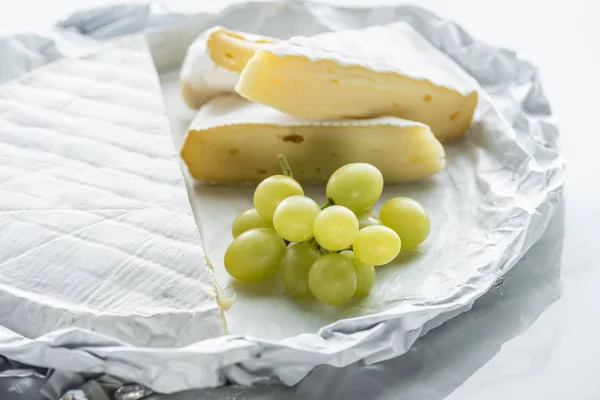Vista de cerca del queso camembert y la uva - foto de stock
