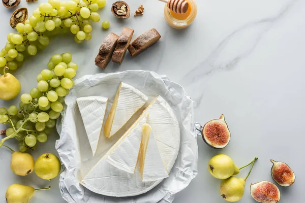 Essenszusammensetzung mit Camembert-Käse, Trauben, Honig und Brot auf weißem Marmor — Stockfoto