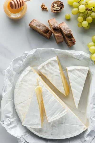 Flat lay with bread, brie cheese and honey on white marble surface — Stock Photo