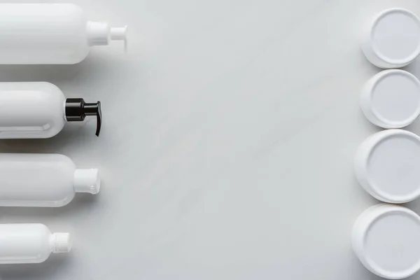 Vue du dessus des bouteilles de crème et lotion sur surface blanche, concept beauté — Photo de stock