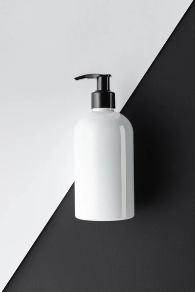 Vista superior de garrafa de creme na superfície preto e branco, conceito de beleza — Fotografia de Stock